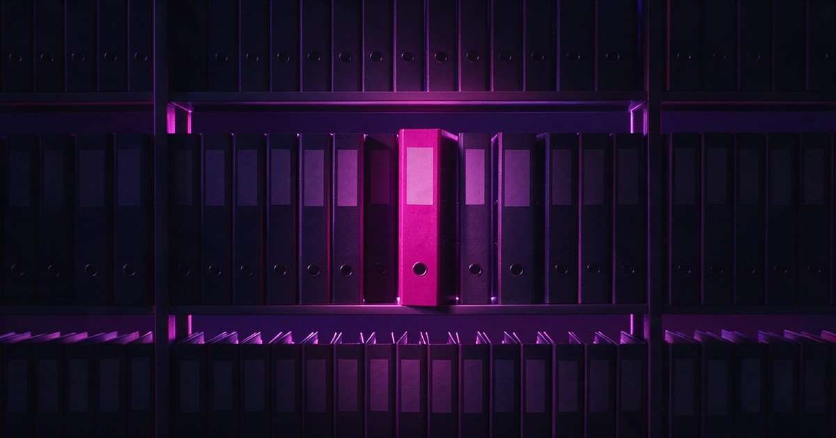 Estante de pastas de arquivo escuras com uma única pasta magenta.